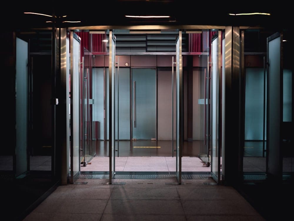 Conjunto de portas de vidro na entrada controlada de um edifício, vistas de fora.